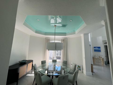 A section of a residential ceiling painted with blue high gloss paint